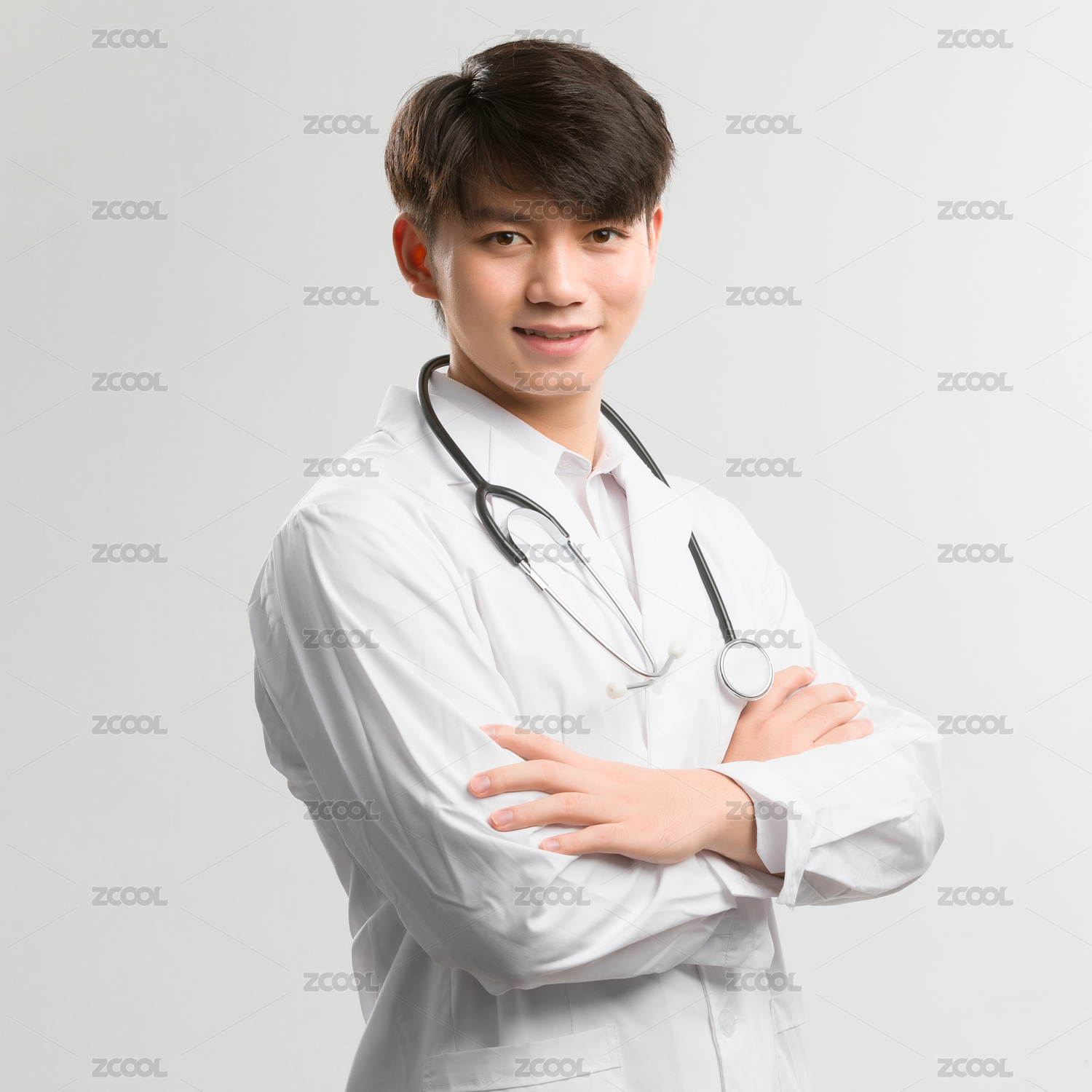 白色背景里双手抱胸的亚洲男医生