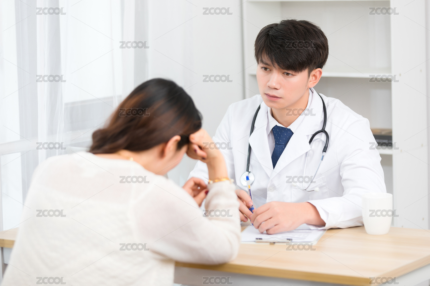 坐在办公室里的亚洲男医生正在询问患者的病情