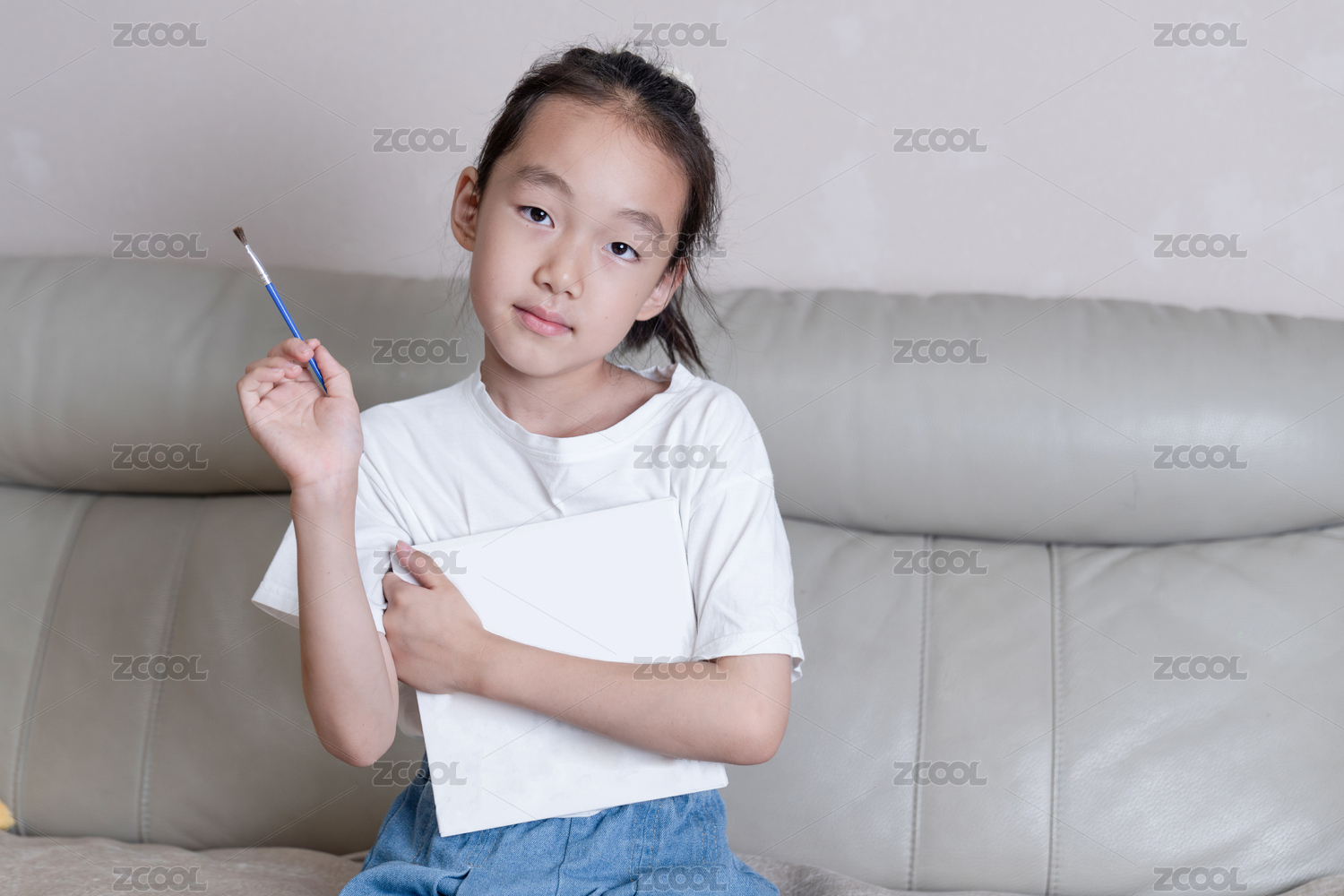 小女孩手拿着画笔抱着绘画板