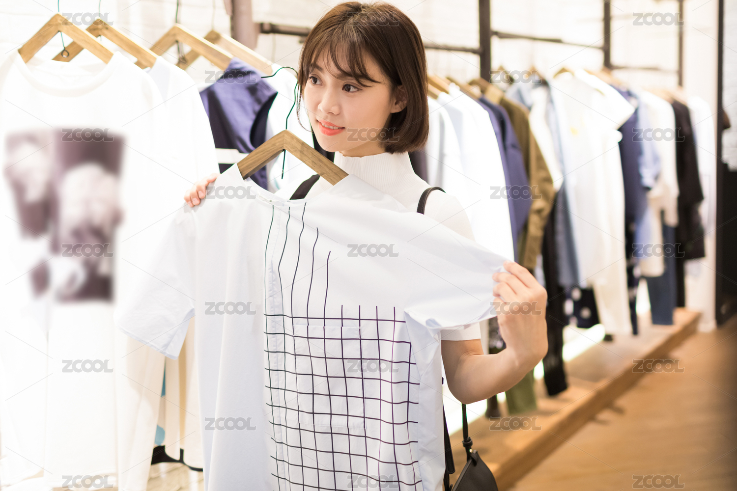 年轻漂亮的年轻女性在商场寻找挑选试穿服装
