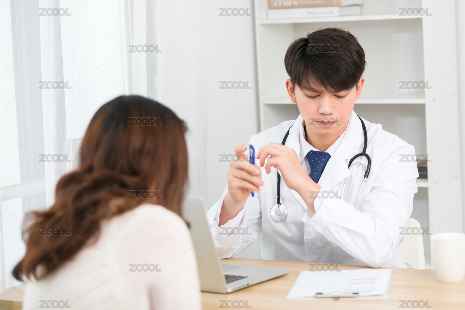 坐在办公室里的亚洲男医生正在询问患者的病情