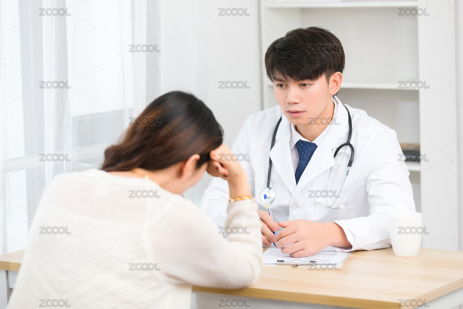 坐在办公室里的亚洲男医生正在询问患者的病情