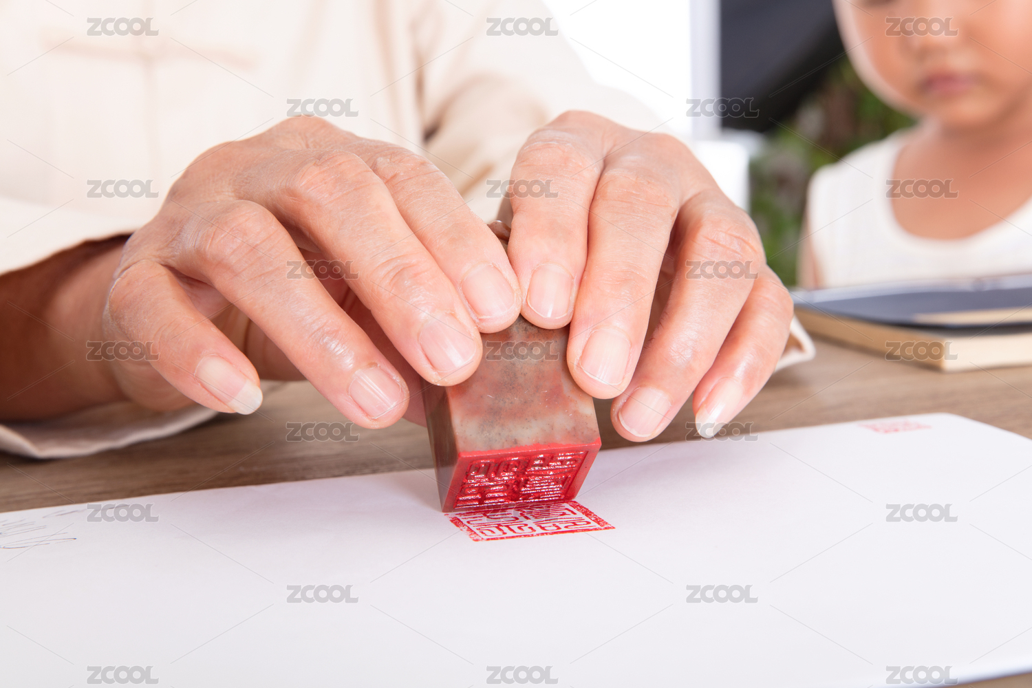 中国人手拿印章在白纸上加盖
