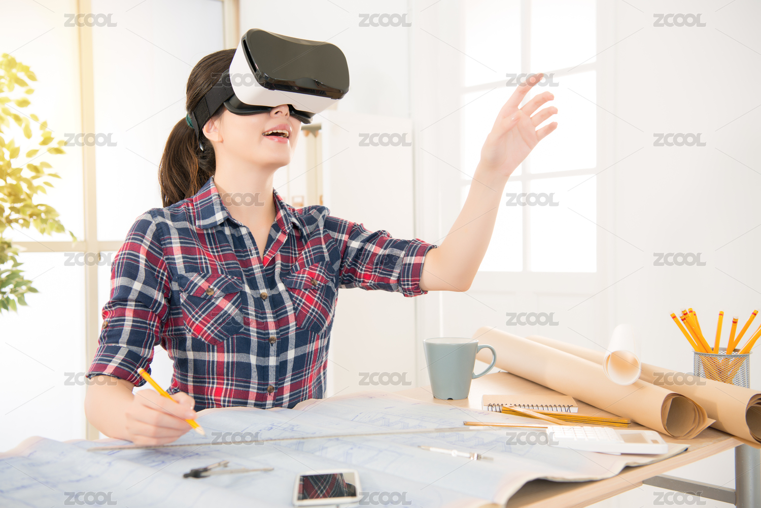 职业和职务侵占的概念。亚洲建筑师女人穿着和经验VR虚拟现实的耳机，虽然在创意办公工作室的办公桌在拿着铅笔绘图设计。