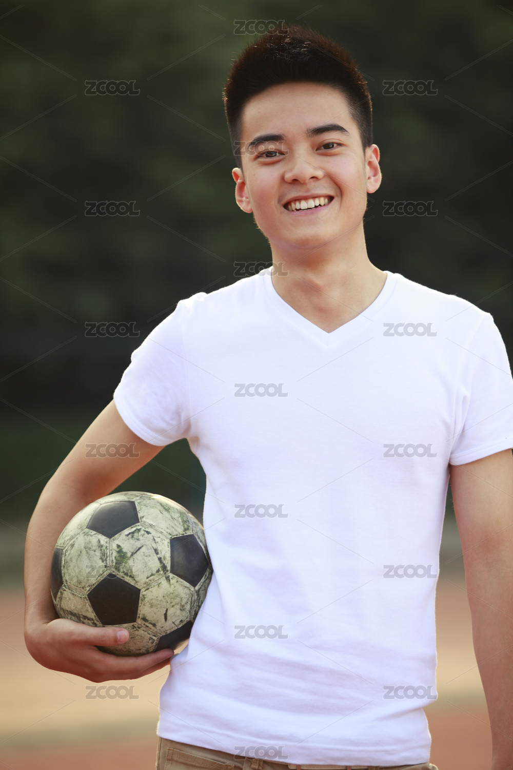年轻的亚洲男子拿着相机foodball微笑