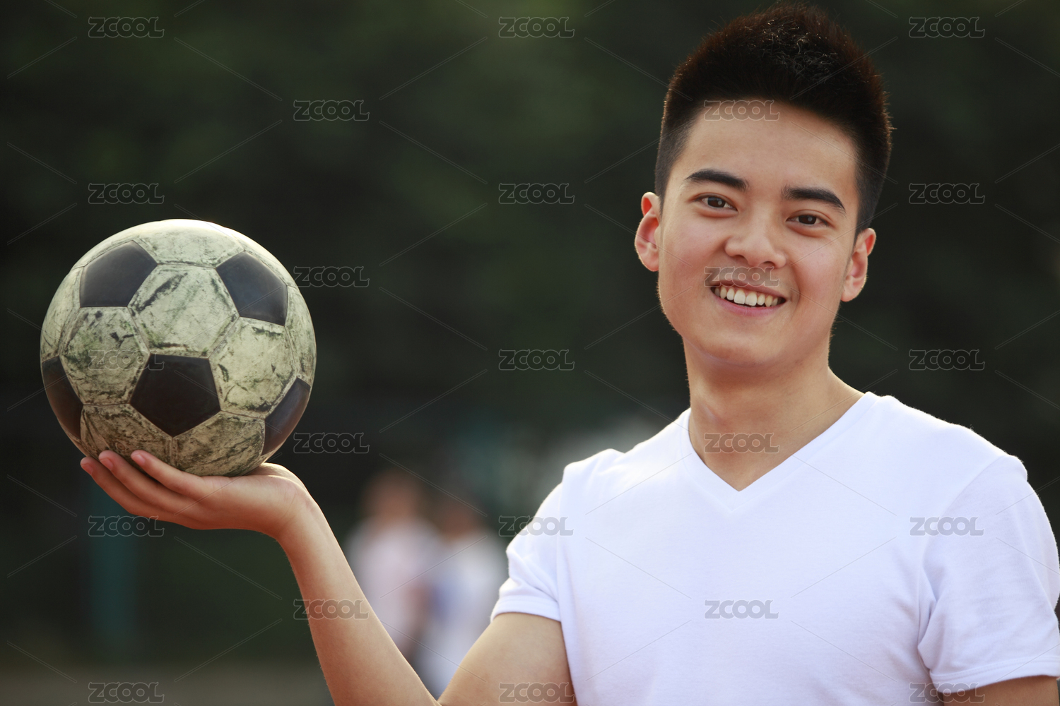 年轻的亚洲男子拿着相机foodball微笑