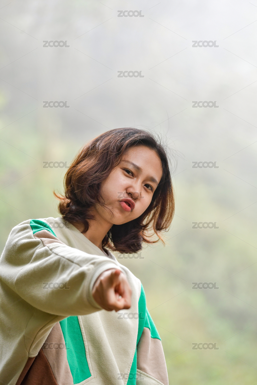 一个亚洲女青年比划剪刀手并开心的嘟嘴