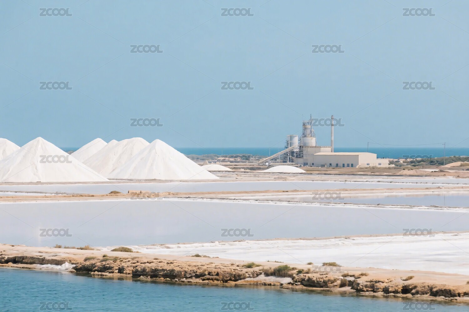 海边盐堆与远处建筑景观