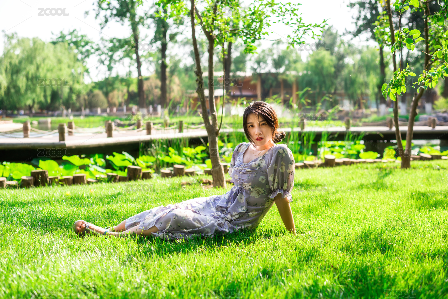 美丽优雅的亚洲女性坐在草地上，夏日午后的花园里，中国古典花园