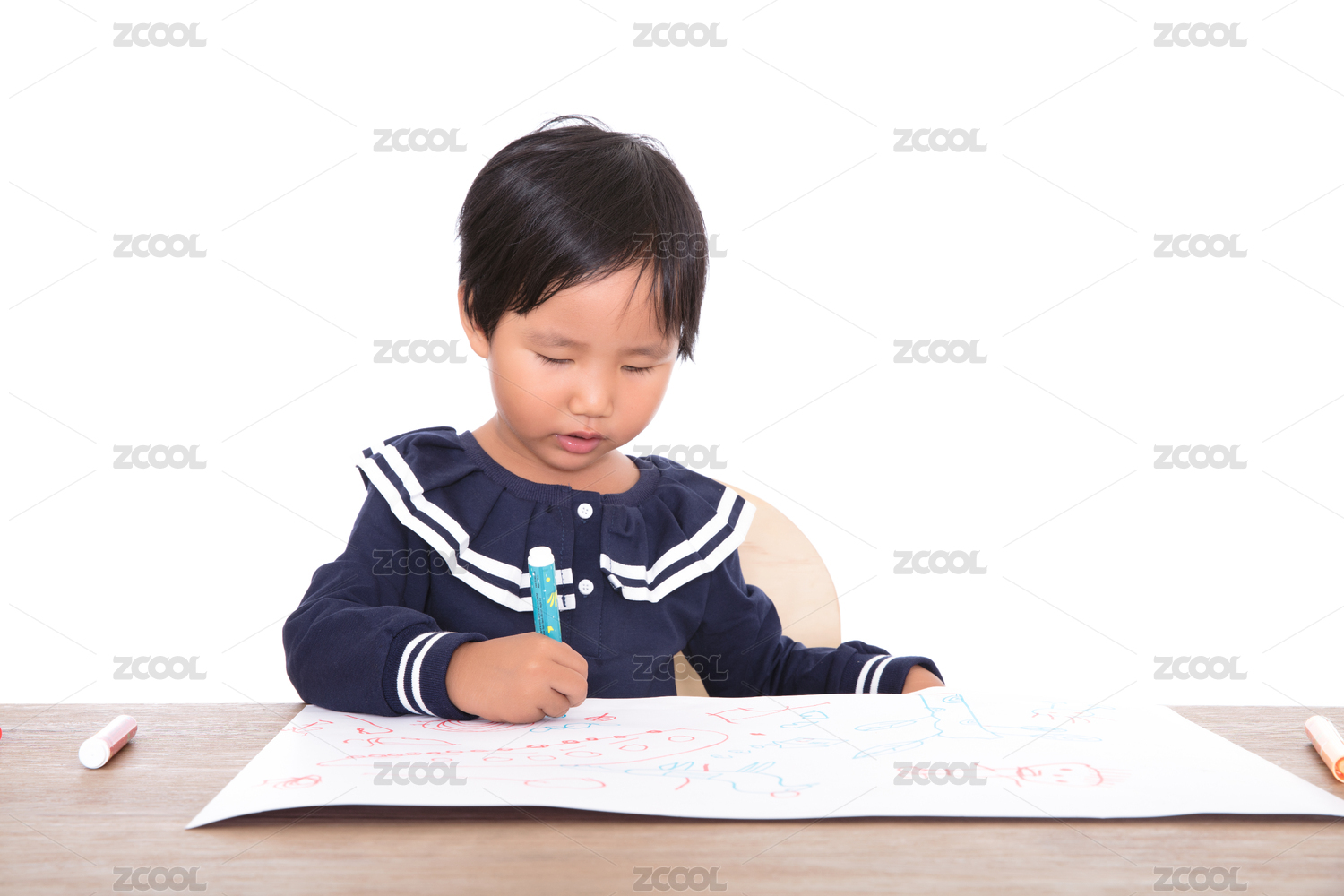 白背景前的书桌旁练习绘画的小女孩