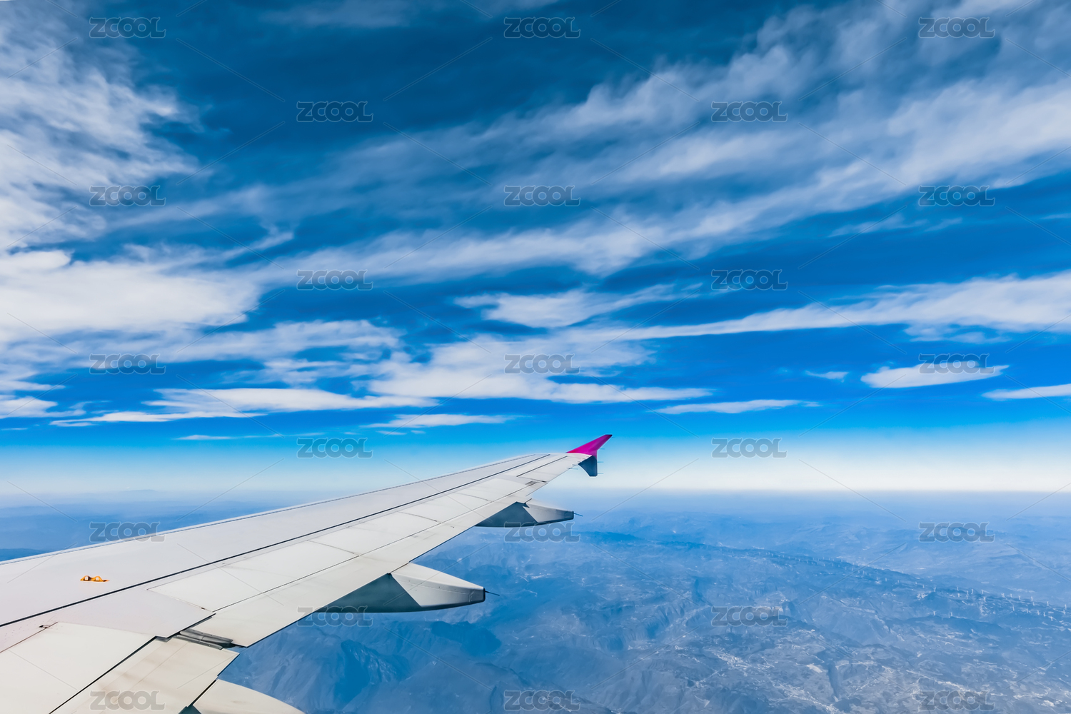 蓝天白云中飞翔的客运飞机翅膀