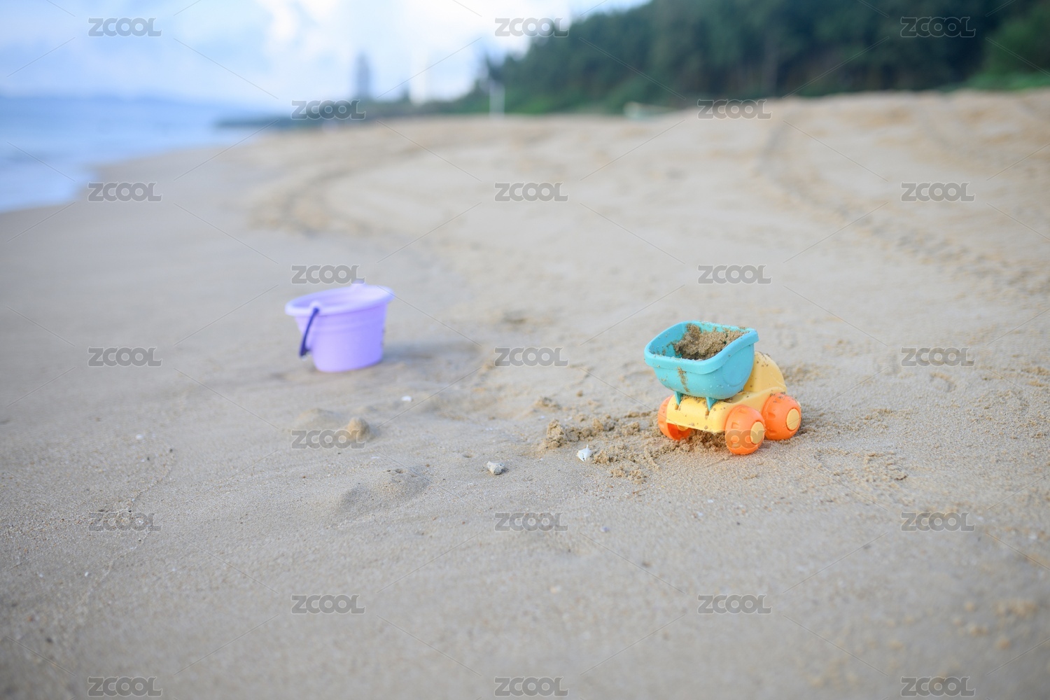 摆在无人海边沙滩上的彩色儿童玩具