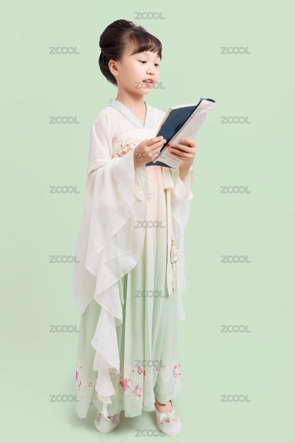 身穿中国古典唐装手拿古书的小女孩棚拍肖像