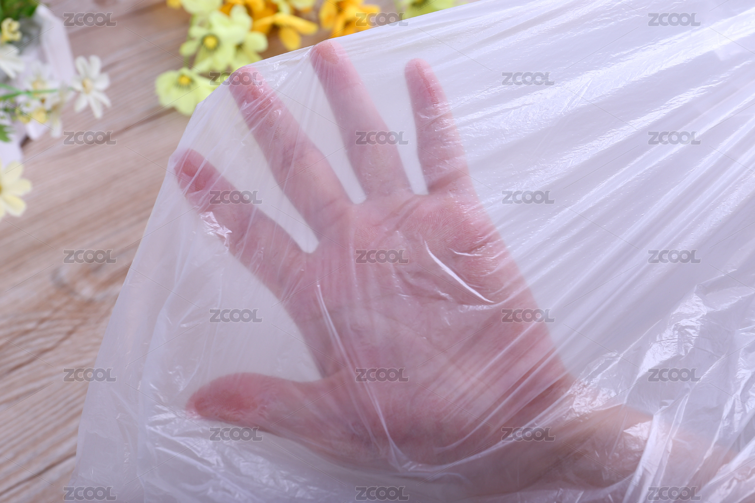 木纹背景上手放在透明塑料袋子下面